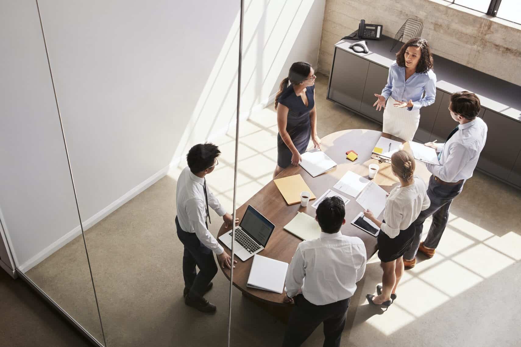 Female manager in team meeting, elevated view through window